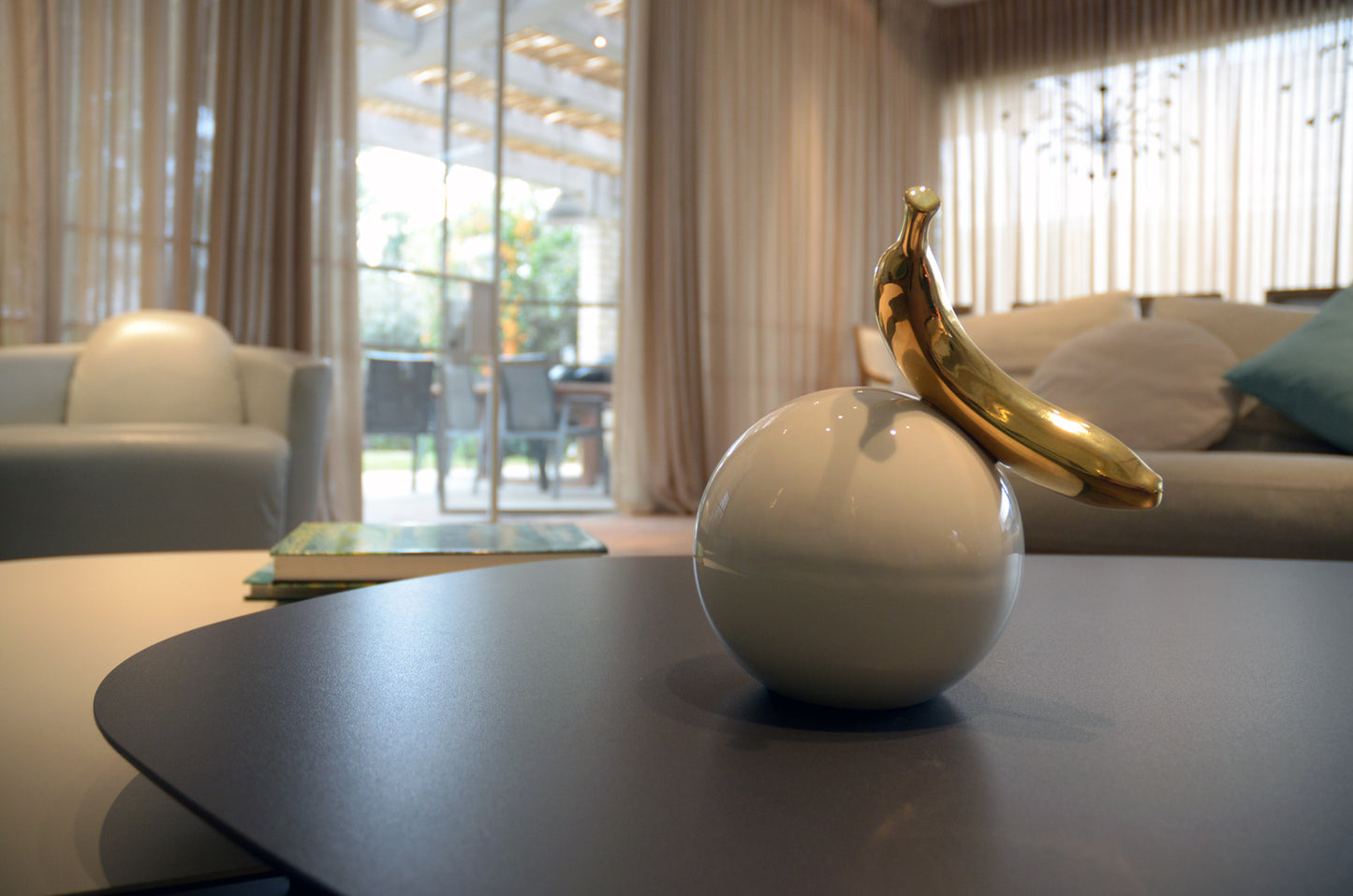 פסל בננה זהב על כדור